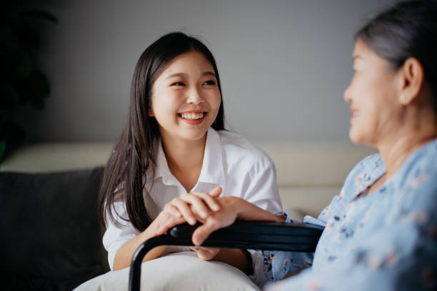 young asian woman holding hand of her grandmother and giving emotional support